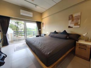 a bedroom with a large bed and a balcony at Stylish Studio Condo on the Beach in Ban Pak Khlong Phe