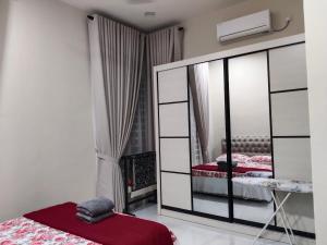 a bedroom with a mirror and a bed at D'Jawa Homestay in Baling