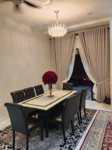 a dining room with a table and chairs and a chandelier at D'Jawa Homestay in Baling