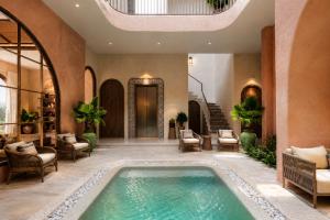 an indoor pool in a house with chairs and a table at Soho Boutique in Quảng Ngãi