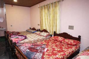 two beds sitting next to each other in a bedroom at Peak Homestay in Kalasa