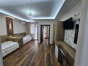 a hotel room with two beds and a tv at Villa Diana Self check-in in Kiten