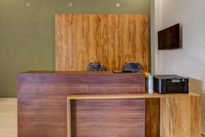 a wooden counter with a desk with a printer on it at Hotel O Utrishree in Khandagiri
