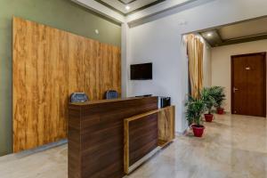 an office lobby with a wooden partition and a tv at Hotel O Utrishree in Khandagiri
