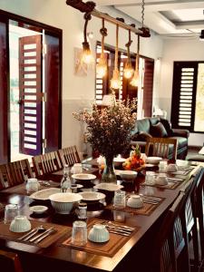 a dining room table with plates and bowls on it at Miu Homestay Hue in Thôn Lại Thê