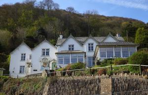 una casa blanca con una valla delante en The Bonnicott Hotel Lynmouth en Lynmouth