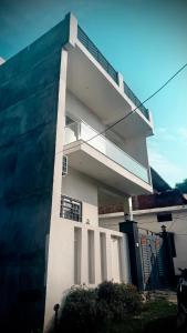 a white building with a balcony on the side of it at Samarpan in Gorakhpur