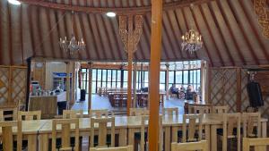 a large room with tables and chairs and chandeliers at Bayalag Resort in Yoliin Hural