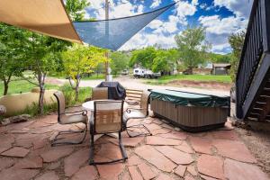 a patio with a table and chairs and a hot tub at Cozy 1BR Mountain View Studio with Fireplace &Deck in Fort Collins