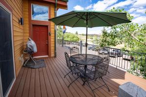 a table and chairs on a deck with an umbrella at Cozy 1BR Mountain View Studio with Fireplace &Deck in Fort Collins