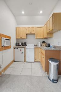 a kitchen with white appliances and wooden cabinets at Cozy 1BR Mountain View Studio with Fireplace &Deck in Fort Collins