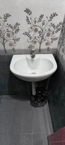 a white sink in a bathroom with a wall at Fantasy Homestay in Thiruchendur