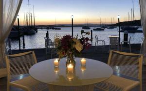 a white table with candles and a vase of flowers on it at Coastal Hideaway at Pelican in Pelican Flat +8 photos
