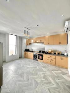 a large kitchen with wooden cabinets and ailed floor at Appartement 2 chambres in Cotonou