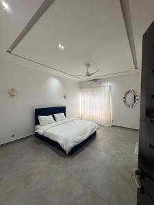a bedroom with a bed in a white room at Appartement 2 chambres in Cotonou
