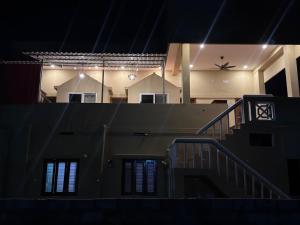 an empty house with a staircase in the dark at Golden Waves Guest House in Mahabalipuram