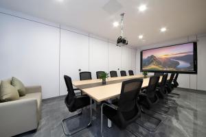 a conference room with a table and chairs and a large screen at 四川思睿博酒店 in Heishui