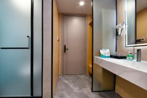 a bathroom with a sink and a mirror and a door at 四川思睿博酒店 in Heishui +32 photos