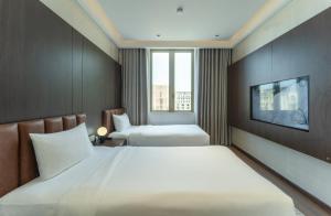 a hotel room with two beds and a tv at Villa 5 phòng ngủ cao cấp in Dong Hoi