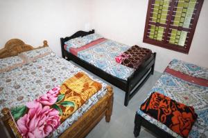 a room with three beds in a room at Aroli Homestay in Kalasa +2 photos