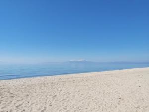 a sandy beach with the ocean in the background at Villa Joanna Seasides , Top Floor in Mesimérion