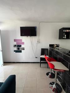a living room with red chairs and a tv on the wall at María 1 in Barahona