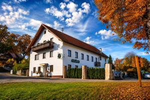 a white building with a brown roof on a street at Hotel Hirsch Fluorn Schwarzwald in Fluorn
