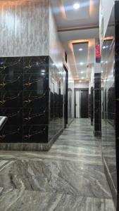 a lobby with black marble walls and a hallway at Sukoon guest house in Jammu