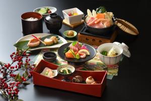 a table with plates of food and bowls of food at Kyukamura Myoko in Myoko