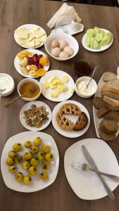 a table full of plates of food with eggs and bread at Hotel Giorgi in Tsqaltubo