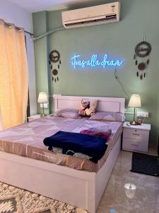 a bedroom with a bed with a sign on the wall at Sugar Waves in Navi Mumbai