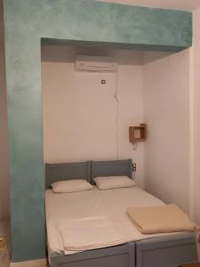 a bed in a room with a blue wall at I have a big dream in Agia Pelagia