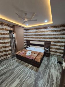 a bedroom with a bed and a brick wall at Sukoon guest house in Jammu