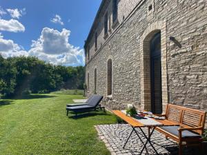 a patio with a table and a chair next to a brick building at Appartment Schafstall - am Unstrutradweg in Wundersleben