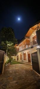a house at night with the moon in the sky at Moksha Villa-Hostel Kandy in Kandy