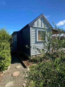 a black and white tiny house in a yard at Kingfisher Cottage in Masterton