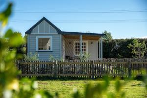 a small house behind a wooden fence at Kingfisher Cottage in Masterton +12 photos