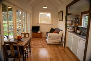 a living room with a table and a kitchen at Kingfisher Cottage in Masterton