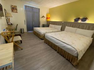 a hotel room with two beds and a table at 東石民宿 湛藍海寓 Azure Seaside House in Dongshi