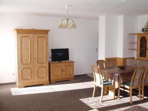 a dining room with a table and chairs and a television at Ferienwohnungen Luxner in Fügen +18 photos
