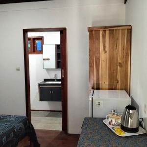 a room with a kitchen with a counter and a table at Gecko Lodge in Tetebatu