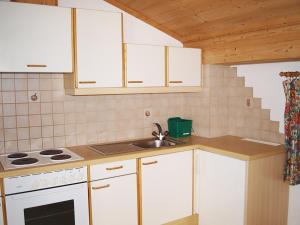 a kitchen with white cabinets and a sink at Ferienwohnungen Luxner in Fügen