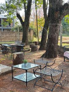 a group of tables and benches in a park with trees at La Alpina playa Nebel in Concordia +17 photos