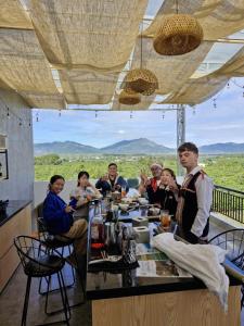 a group of people sitting at a table in a restaurant at Pleiku Adventures Homestay in Bien Ho