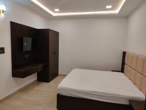 a bedroom with a bed and a tv on a wall at Hotel Empress Gold in Agra