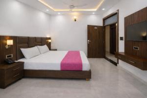 a bedroom with a bed and a flat screen tv at Hotel Empress Gold in Agra