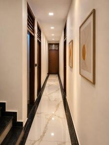 a hallway with white walls and a tile floor at Hotel Empress Gold in Agra