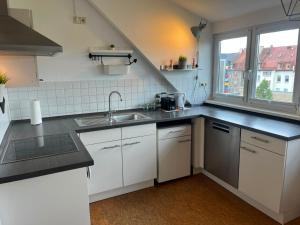 a kitchen with white cabinets and a sink and a window at Süße Marie 18 - Coffee for free - in Karlsruhe +12 photos