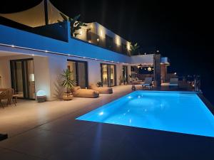 a large swimming pool in a house at night at Villa Westwood in Parga +57 photos
