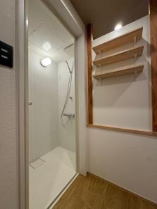 a bathroom with a shower and a walk in closet at Besso城前 in Himeji